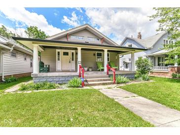 Charming home with a welcoming front porch, well-maintained lawn, and red railing, blending character and curb appeal at 518 N Emerson Ave, Indianapolis, IN 46219
