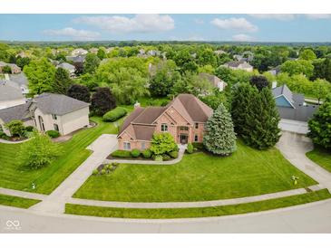 A well-maintained two-story brick home with a landscaped front yard and a long concrete driveway at 5251 Apache Moon, Carmel, IN 46033
