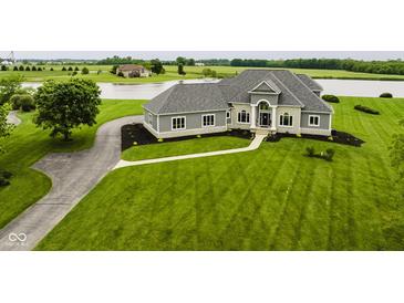 Stunning home boasts manicured lawn and stone accents near a serene lake at 5758 N 900 W, Thorntown, IN 46071