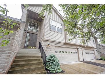 Charming townhome exterior with brick accents, attached garage, and landscaped front yard at 9117 Thoreau Ct, Fishers, IN 46037