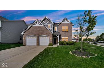 Charming two-story brick home featuring a two-car garage and beautifully landscaped front yard at 9717 Chuckwalla Pl, Fishers, IN 46040