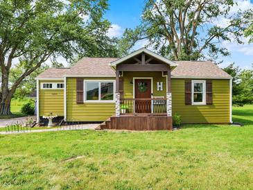 Charming home featuring green siding, brown shutters, and a covered porch with a decorative front door at 10854 E 700 N, Wilkinson, IN 46186