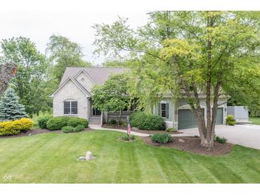 Charming stone and siding home with a well-manicured lawn, lush landscaping, and a welcoming front porch at 11020 Florida Rd, Fortville, IN 46040