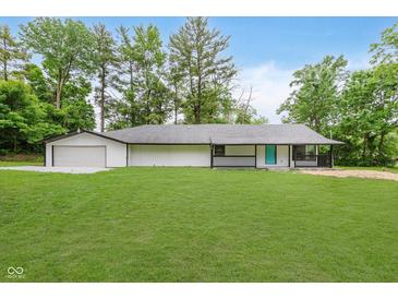 Charming single-story home with a well-maintained lawn and a bright turquoise front door at 233 N Devon Ave, Indianapolis, IN 46219