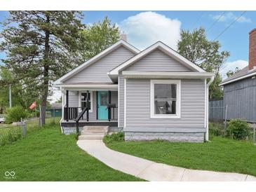 Charming home with a well-maintained lawn and a bright turquoise front door at 2531 E Brookside Ave, Indianapolis, IN 46218