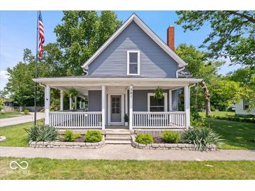 Charming home featuring a cozy front porch with white railings and manicured landscaping at 301 S Main St, Whitestown, IN 46075