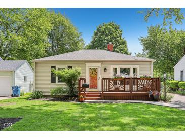 Charming bungalow-style home featuring a cozy front deck, well-maintained lawn, and colorful flower planters at 5333 Ralston Ave, Indianapolis, IN 46220