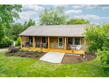 Inviting exterior featuring a lovely front porch, stone accents, and well-maintained landscaping at 5730 S 50 W, Trafalgar, IN 46181