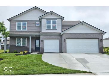 Charming two-story home with a two-car garage, landscaped yard, and a welcoming covered front porch at 6049 Madera Dr, Whitestown, IN 46075