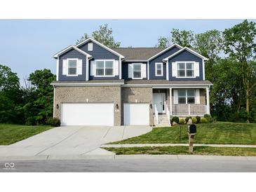 Charming two-story home featuring a brick facade, a two-car garage, and a well-manicured lawn at 6377 Harvey Dr, Plainfield, IN 46168
