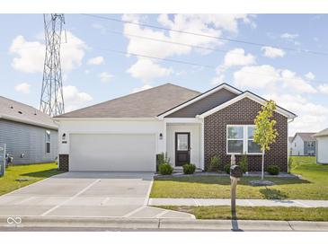 Charming single-story home with brick accents, a well-manicured lawn, and a two-car garage at 7431 Stillness Dr, Indianapolis, IN 46268