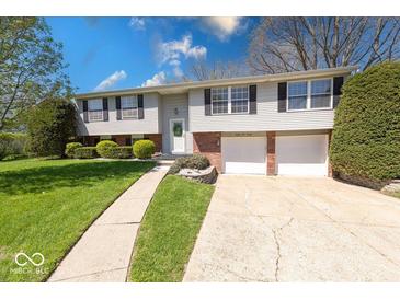 Charming two-story home with a well-maintained lawn and attached two-car garage at 8120 Trevellian Way, Indianapolis, IN 46217
