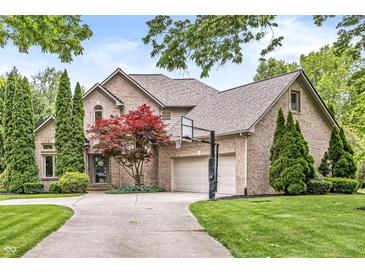 Lovely two-story brick home featuring an attached three car garage, basketball hoop and beautiful landscaping at 10697 Woodmont Ln, Fishers, IN 46037
