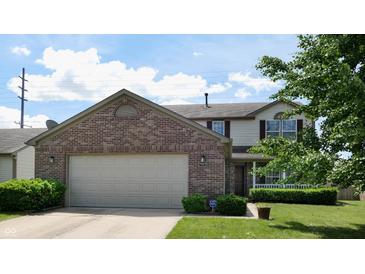 Charming two-story home featuring a brick facade, attached two-car garage, and manicured front yard at 1129 Central Park S Blvd, Greenwood, IN 46143