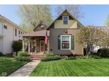 Charming home featuring a covered porch, well-manicured lawn, and an American flag display at 1352 Clinton St, Noblesville, IN 46060
