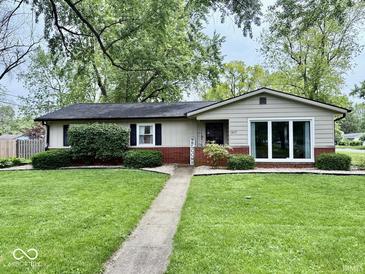 Charming single-story home with a well-manicured lawn and landscaped garden beds at 1917 W Norwood Dr, Muncie, IN 47304