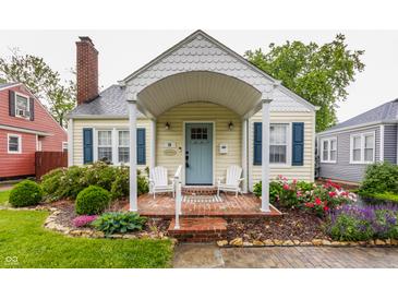 Charming home featuring a brick front porch with white Adirondack chairs and a light blue front door at 28 N Elizabeth St, Indianapolis, IN 46219