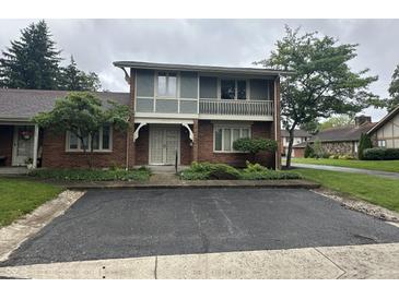 Charming two-story townhome with brick facade, upper balcony, and manicured front yard at 3975 Offshore Dr, Columbus, IN 47203