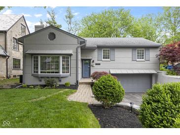 Charming two-story home with landscaped front yard, updated exterior, brick walkway, and attached two car garage at 5543 N Pennsylvania N St, Indianapolis, IN 46220
