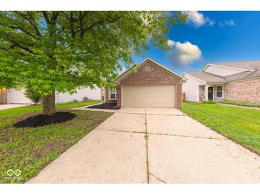 Charming brick home featuring an attached garage and a well-maintained front yard at 5633 Fox Glove Ln, Indianapolis, IN 46254
