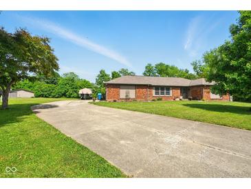 Single story brick home featuring an extra long driveway and well-maintained landscaping at 564 Penright Ct, Indianapolis, IN 46217