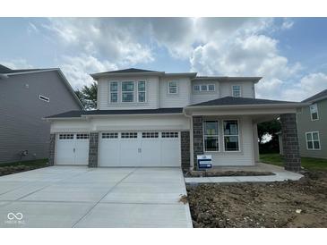 Charming two-story home featuring a three car garage and modern architectural details, enhancing its curb appeal at 6761 Seabiscuit Rd, Whitestown, IN 46075
