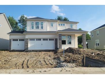 New two-story home with a three-car garage and stone accents awaiting landscaping at 6761 Seabiscuit Rd, Whitestown, IN 46075