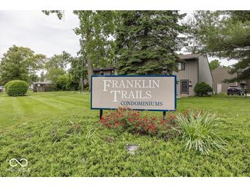 Community sign for Franklin Trails Condominiums with landscaped bushes and trees at 7940 Benjamin Dr, Lawrence, IN 46226