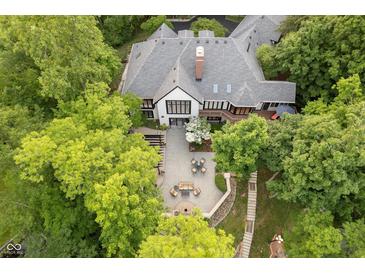 Stunning aerial view of a luxurious home with a stone patio, outdoor seating, and lush landscaping at 8301 Reef Ct, Indianapolis, IN 46236