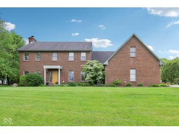 Traditional two-story brick home with a lush lawn and manicured landscaping in a peaceful neighborhood at 1121 N Cambridge Ct, Greenfield, IN 46140