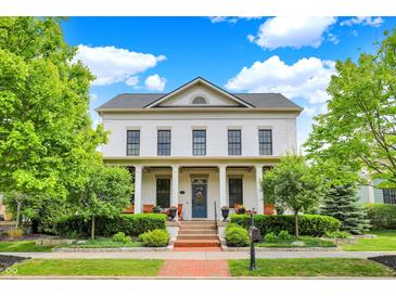 Charming two-story white brick home featuring a welcoming front porch and manicured landscaping at 12999 Deerstyne Green St, Carmel, IN 46032