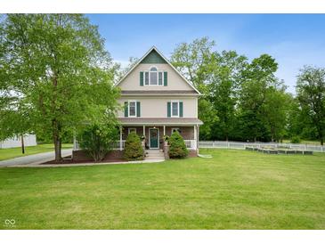 Charming two-story home with a large front yard and beautiful landscaping in a peaceful, wooded setting at 2708 N 400 E, Greenfield, IN 46140