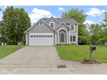 Charming two-story home features a well-manicured lawn and attached two-car garage at 3014 Saddlehorn Dr, Carmel, IN 46033