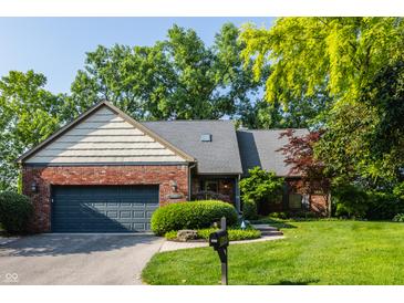 Charming brick home featuring an attached garage and a beautifully maintained lawn at 3585 Bay Rd N Dr, Indianapolis, IN 46240