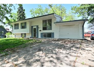 Charming home with light colored siding, updated windows, attached garage, and driveway at 3668 Chatsbee Ct, Indianapolis, IN 46224