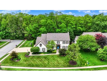 Charming home with lush landscaping and a well-manicured lawn, nestled in a serene, tree-filled neighborhood at 5268 Woodfield Dr N, Carmel, IN 46033