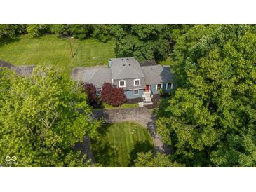 Aerial view of a charming home with a well-manicured lawn and mature trees at 5506 Kessler Blvd N Dr, Indianapolis, IN 46228