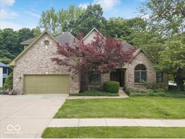 Charming brick home with a two-car garage, manicured lawn, and mature trees in a desirable neighborhood at 6363 Harmonridge Ct, Indianapolis, IN 46278