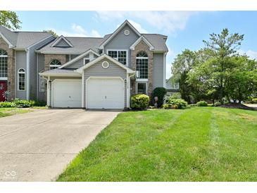 Charming two-story home features a two-car garage and well-manicured lawn and attractive curb appeal at 7529 Oceanline Dr, Indianapolis, IN 46214