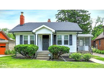 Charming home featuring manicured lawn, mature shrubbery, and a cozy front porch entrance at 907 N Arlington Ave, Indianapolis, IN 46219