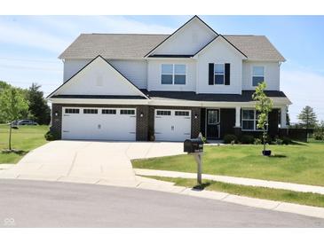 Charming two-story home featuring a three-car garage, well-manicured lawn, and inviting curb appeal at 9640 Katana Cir, Fishers, IN 46040