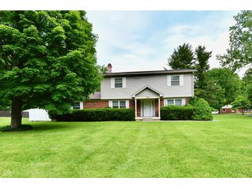 Charming two-story home featuring well-maintained landscaping and a lush green lawn at 1102 Fox Hill Dr, Indianapolis, IN 46228