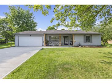 Charming single-story home with a well-manicured lawn and inviting front porch at 1121 Barcelona Dr, Greenwood, IN 46143