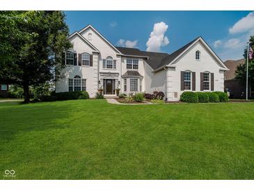 Charming two-story painted brick home with a manicured green lawn at 13218 Beckwith Dr, Carmel, IN 46074