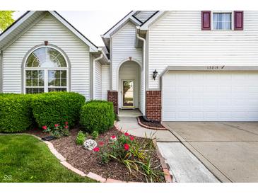 Charming home featuring a brick-accented entrance and manicured landscaping, enhancing its curb appeal at 13815 Plantree Dr, Carmel, IN 46033