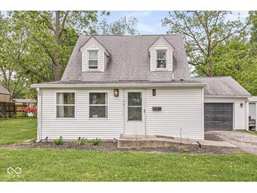 Charming cottage-style home with white siding, dormer windows, green lawn, and attached garage at 2 S 25Th Ave, Beech Grove, IN 46107