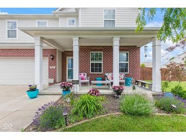 Inviting front porch featuring brick accents, stylish decor, and manicured landscaping at 2337 Hanover Rd, Brownsburg, IN 46112