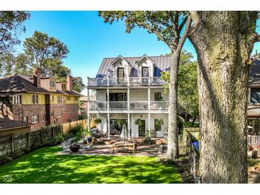 Spacious two-story home with backyard featuring a patio, lush lawn, and mature trees at 3215 N Pennsylvania St, Indianapolis, IN 46205