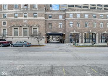 The property's brick exterior includes covered parking and a walkway, all in an urban setting at 350 N Meridian St # A303, Indianapolis, IN 46204