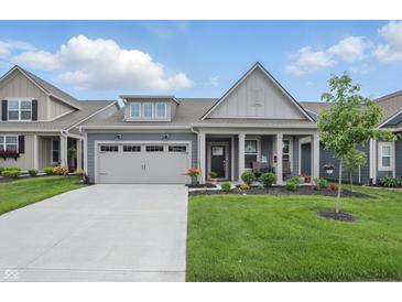 Charming home showcasing a well-manicured lawn, a two-car garage, and a cozy front porch with elegant columns at 395 Ehrlich Ln, Westfield, IN 46074